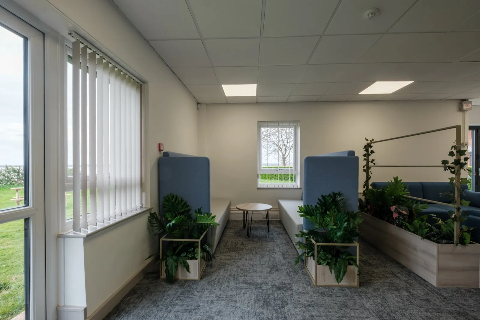 Acoustic high-back booth seating with planters creating a quiet zone at Boluda Towage